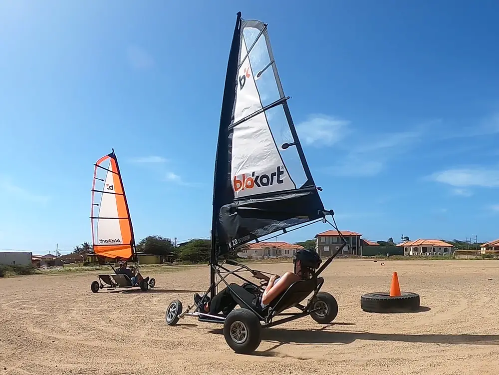 man and woman land-sailing in blokarts on a dirt field in Aruba