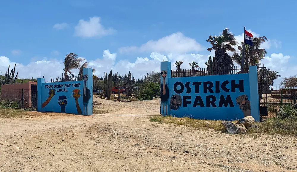 blue entrance sign for the Aruba Ostrich Farm