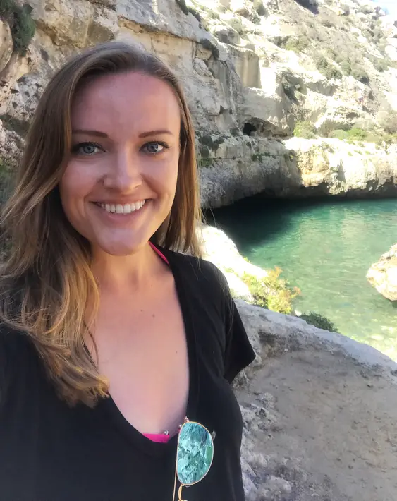 woman standing beside a natural pool in Malta