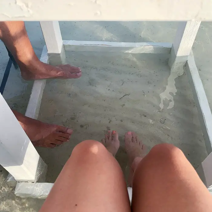 feet in the water at Flying Fishbone Restaurant in Aruba
