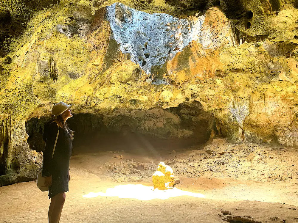 woman standing inside Guadirikiri Cave in Arikok National Park in Aruba