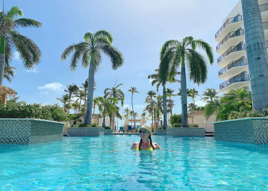 woman in a swimming pool surrounded by palm trees at the Marriott Resort in Aruba