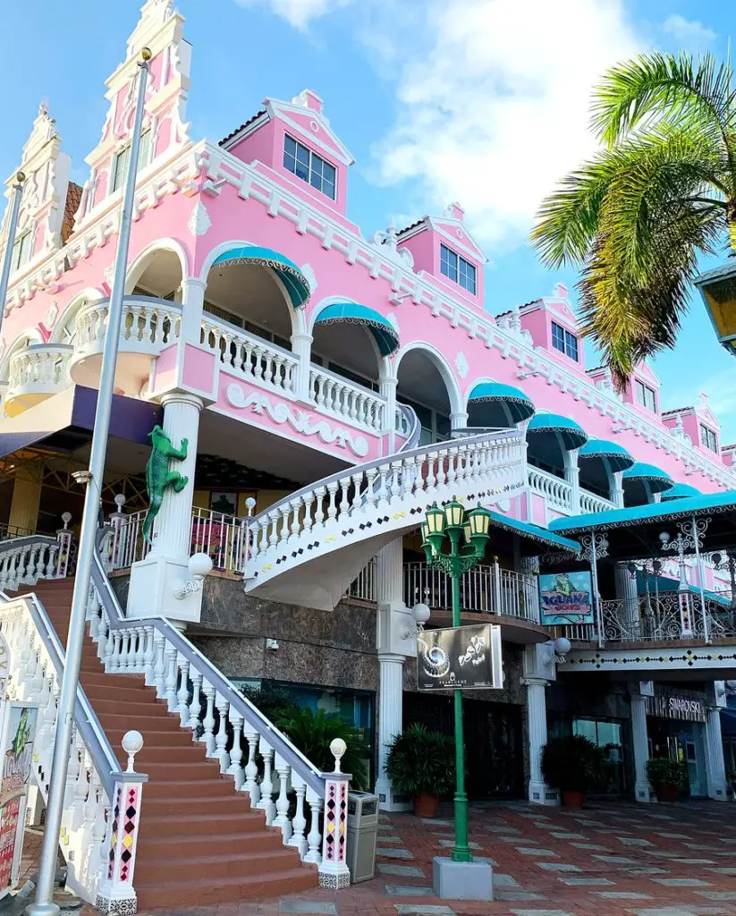 pink and white Royal Plaza Mall building with blue awnings in Oranjestad, Aruba