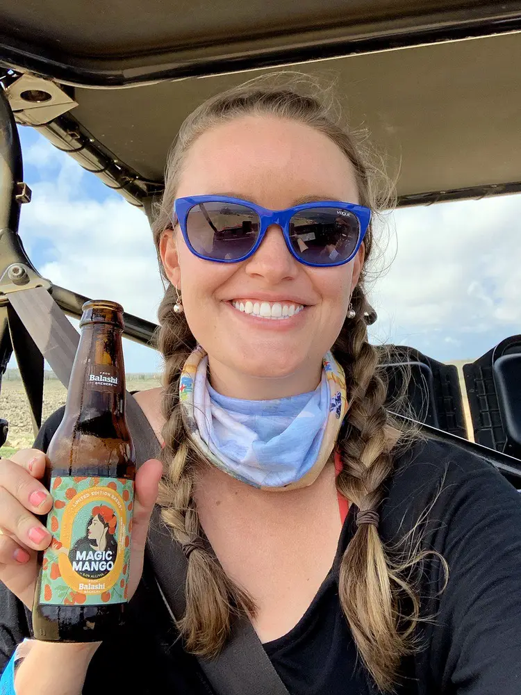 woman holding a Balashi beer