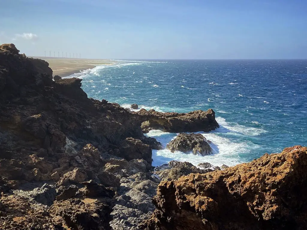 blue waves crashing against cliffs of volcanic rock in the Seroe Colorado area of Aruba