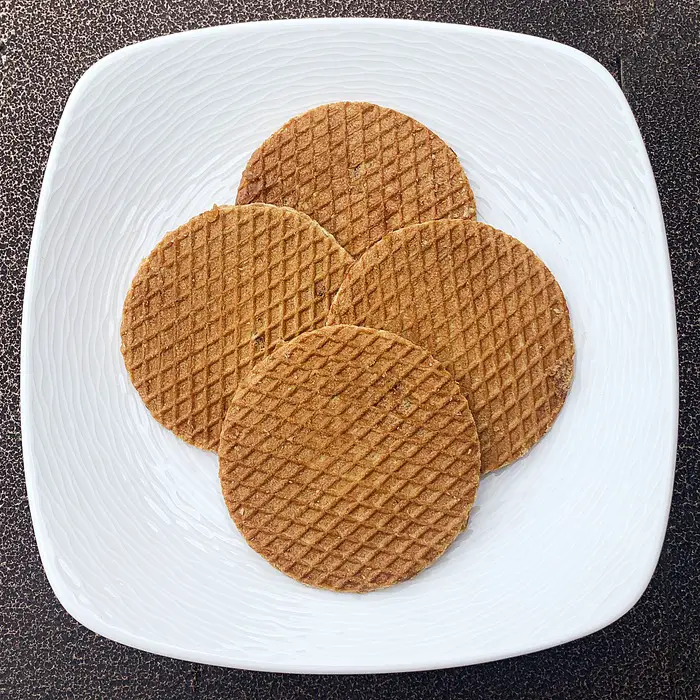 four stroopwafels on a white plate