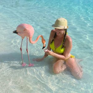 woman feeding a flamingo at Flamingo Beach in Aruba